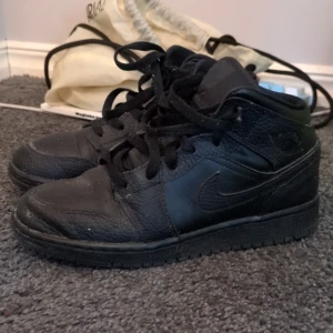 Svarta Nike Air Jordans - Säljer ett par klassiska svarta Nike Air Jordans. Skorna har en stilren design med snörning och rund tå. Perfekta för dig som vill ha en tidlös look med komfort.