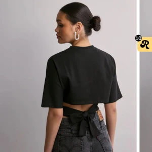 Svart kortärmad topp med knyt - Snygg svart topp med korta ärmar och knytning i ryggen. Säljer då den inte kommer till användning 💗