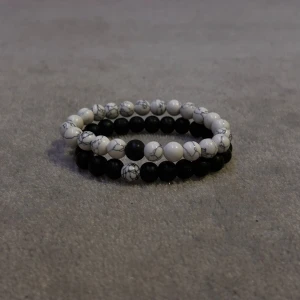 Svart och vitt pärlarmband - Två stilrena armband med pärlor i svart och vitt. Perfekt för att komplettera din outfit med en elegant touch. Armbanden kan bäras tillsammans eller separat för olika stilar.