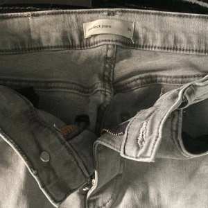 Grå bootcut jeans - Snygga grå bootcut jeans från Gina tricot. De har en klassisk femficksdesign och stängs med dragkedja och knapp. Perfekta för en avslappnad stil med en modern touch. Säljer då jag inte passar den längre. Kan såklart diskutera om pris💗