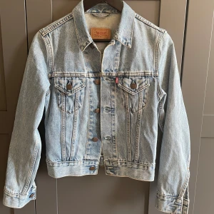 Jeansjacka från Levi's - Jeansjacka från Levi's i storlek XS, kort modell. Den har knappar framtill och två bröstfickor med knapp. 