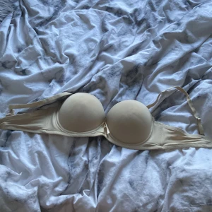 Beige bh med vadderade kupor - Säljer en beige bh med vadderade kupor och justerbara axelband. Perfekt för en bekväm och stilren look under kläderna.