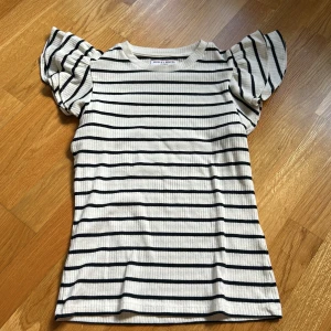 Randig topp från Holly & Whyte - Säljer en söt randig topp från Holly & Whyte by Lindex med fina volang ärmar💗Väldigt bra skick