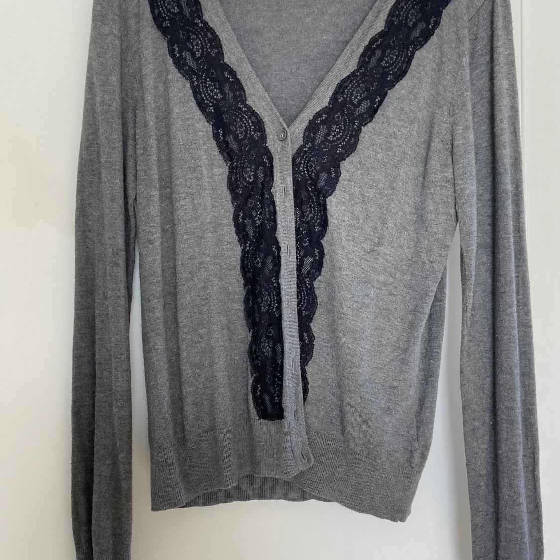 Grå kofta med spetsdetaljer