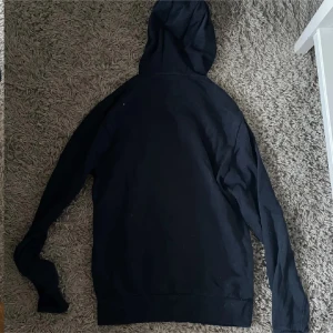 Svart och grön hoodie - Två hoodies i svart och grön färg. Båda har långa ärmar och en praktisk ficka framtill. Perfekta för en avslappnad stil med justerbar huva.