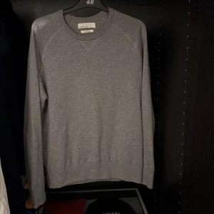Grå tröja från Massimo Dutti - Säljer en stilren grå tröja från Massimo Dutti. Tröjan har en klassisk design med långa ärmar och rund hals. Bra skick utan några defekter. Kontakta för fler bilder eller funderingar. Pris kan diskuteras vid snabb affär
