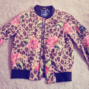 Blommig leopardmönstrad bomberjacka från Blount & Pool - Säljer en unik bomberjacka från Blount & Pool med ett coolt leopard- och blommönster i rosa och grönt. 