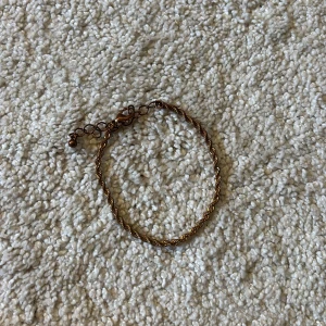 Tunt tvinnat guldarmband - Snyggt och enkelt armband i guldton med tvinnad kedja och justerbar längd. Perfekt för att ge din outfit en stilren touch. Lätt att matcha med andra smycken och passar både till vardags och när du vill känna dig extra fin.