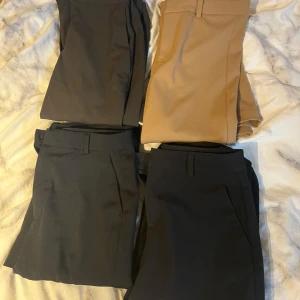 Kostymbyxor från H&M, Vero Moda & Gina Tricot - Fyra par stilrena kostymbyxor i svart, mörkgrått och beige. Ifrån H&M, Vero Moda och Gina Tricot. Byxorna har raka ben, hällor för bälte och klassisk passform. Perfekta för en clean och snygg look. Materialet känns mjukt och följsamt. KOM MED PRISFÖRSLAG 🥰☺️