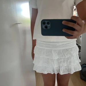 Vit volangkjol med broderade detaljer - Supersöt vit kortkjol med flera volanger och broderade blommor💞 står inget märke eller storlek men passar XSS och XS🥰