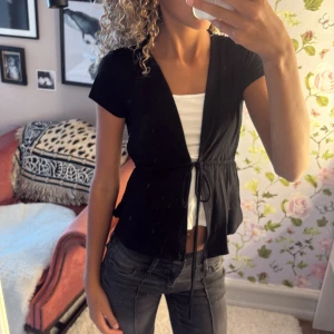 Söt blus|tröja  - Snygg svart blus med kort ärm och knyt i midjan. , perfekt att styla över ett linne eller topp. Jätteskönt material från gina tricot💞💕💕💞