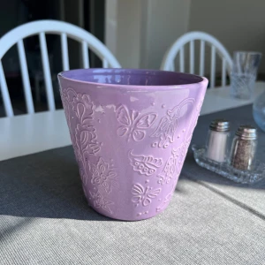 Lila vas med blommor och fjärilar - En gullig lila vas med blommor och fjärilar. Passar perfekt till vilken bukett blommor som helst 💐 Önskar du veta exakta mått? Tveka inte att höra av dig!