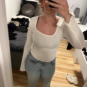 Vit långärmad topp Gina Tricot S - Säljer en vit långärmad topp från Gina Tricot i storlek S. Modellen är tight med fyrkantig ringning och långa ärmar med slits . Tunt och stretchigt material som sitter snyggt och markerar figuren. Perfekt att styla med jeans eller kjol.