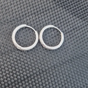 Silverfärgade creoler - Säljer ett par stilrena creoler i silver med glittrig, ovanlig sandblästrad yta. De är runda och ca 2 cm i diameter. Äkta silver, stämplade 925.