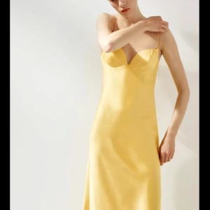 Gul långklänning i satin - Supersnygg gul långklänning med tunna axelband och figurnära passform. Använd 1 gång och är i bra skicka. Jag är 169 cm.🙂