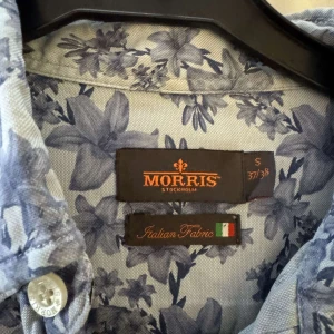 Skjorta från Morris - Snygg skjorta från Morris i ljusblått med blommigt mönster. Sparsamt använd! 