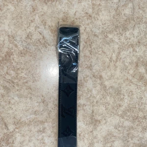 Svart L bälte med silver logga -  svart L bälte med silvrig logga 110cm