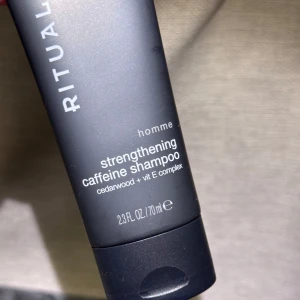 Nytt! Rituals Homme Caffeine Shampoo 70ml - Nytt! En svart tub med Rituals Homme strengthening caffeine shampoo, 70 ml. Innehåller cederträ och vitamin E-komplex för extra vård. Snygg och stilren design, perfekt att ha med i gymväskan eller på resan.