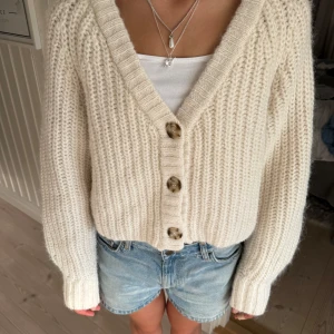 Stickad kofta  - Sjukt mysig beige stickad kofta med stora bruna knappar framtill och v-ringning. 🩷