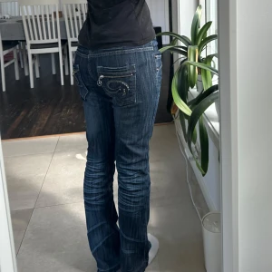 00s jeans - Jeansbyxor med wash och broderade bakfickor. Straight fit och lågmidjade. Midjemått: 44cm Ytterben: 101cm Innerben: 81cm Benöppning: 21cm