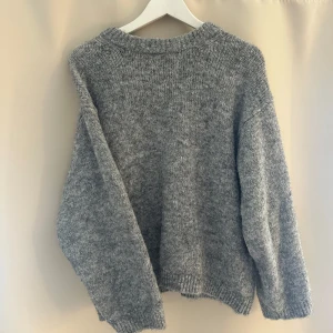Grå stickad tröja - Mysig grå stickad tröja med rund hals. Lite oversize så passar S-M. Använd fåtal gånger!