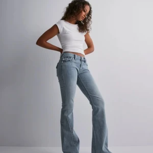 true religion NY jeans - Snygga ljusblå jeans med bootcut-passform och klassiska fem fickor. Jeansen har låg midja och subtila slitningar för en trendig look. Perfekta till vardags och lätta att matcha med olika toppar.