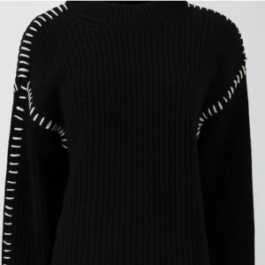 Svart stickad tröja med vita detaljer - Säljer en svart stickad tröja med vita sömdetaljer längs axlar och ärmar. Tröjan har ribbad struktur. Köpte tröjan på Plick men kommer inte till användning så därför säljer💓tröjan är i XS men passar också S.