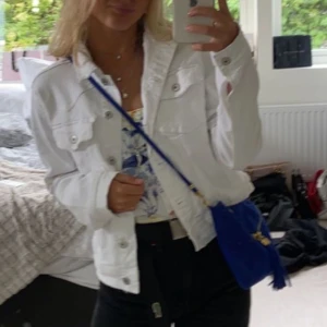 Vit jeansjacka från Zara - Säljer en snygg vit jeansjacka från Zara i storlek L. Jackan har en klassisk design med knappar framtill och två bröstfickor. Perfekt för vår och sommar, och den är i mycket bra skick. Passar både till vardags och fest! Mycket liten i storleken så den är en XS och S.