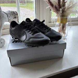 Svarta Nike Tiempo elite 9 (oanvändna fotbollsskor) - Säljer ett par helsvarta Nike Tiempo elite 9 efter jag köpt dem och de var för små. De är extremt svåra att få tag på och jag rekommenderar verkligen. De säljs för en billig peng eftersom jag behöver kunna köpa nya fotbollskor snabbt inför säsongen✅
