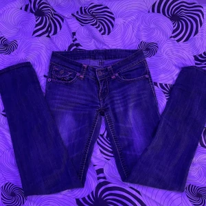 Mörkblå jeans från True Religion - Säljer ett par mörkblå jeans från True Religion med klassiska kontrastsömmar och snygga fickdetaljer bak. Byxorna har normal passform och raka ben. Perfekta för dig.