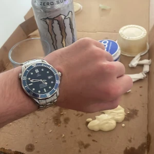 Omega Seamaster herrklocka med blå urtavla - jäte fin kloka, ursäkta bakgrund (äta piza). köpa kanske???