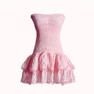 Sommarklänning med volanger - Thyra  - Supersöt rosa axelbandslös sommarklänning med smockad överdel och volangig kjol. Helt sprillans ny, köpte tyvärr fel storlek och vill inte gå igenom en långdragen returprocess då de verkar ha svajig returpolicy. Köpt för 600 kr