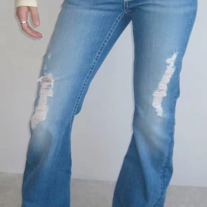 Blå lågmidjade bootcut jeans med slitningar från Gina tricot  - Intressekoll på dessa super snygga jeans från Gina tricot i storlek S. endast använda en gång! Skriv för egna bilder och om ni är intresserade, tryck inte köp nu!!!