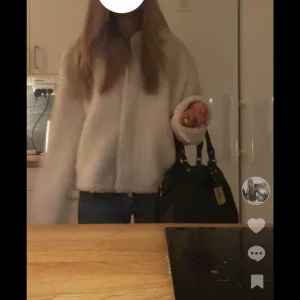 Vit teddyjacka med krage - Säljer en fluffig vit teddyjacka med krage. Jackan är midjelång och har lång ärm, perfekt för att hålla värmen. Enkel och stilren design som passar till jeans eller kjol. Stängs framtill och är supermjuk.