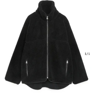 Svart teddyjacka från arket - Svart teddy jacka från arket. Nyskick men lite mohair på jackan som lätt går att peta av, dvs inga defekter som inte går att fixa. Nypris är runt 1,3. Säljer pga att jag inte använder så mycket. Perfekt för vår och höst!!!! 