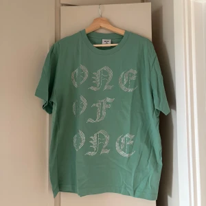 Grön t-shirt från One of One - Säljer en grön t-shirt från One of One med diamanttryck. T-shirten har en klassisk passform och är tillverkad i mjuk bomull. Perfekt för dig som gillar streetwear och unika plagg.