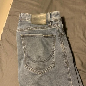 Blå jeans från Superdry - Säljer ett par klassiska blå jeans från Superdry med normal passform. Jeansen har fem fickor, diskret Superdry-logga vid bakfickan och raka ben. Perfekta till vardags för en avslappnad stil.
