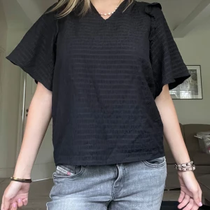 Svart blus från Mayla - Säljer denna superfina svarta blus med korta volangarmar. Perfekt till jeans eller kjol, den säljs inte längre i butik! Säljer nu endast för 400 kr🤩