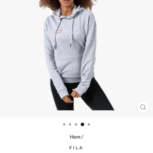Grå hoodie från FILA - Säljer en grå hoodie från FILA med vit och röd logga framtill. Tröjan har huva  och en stor magficka. Perfekt för en avslappnad stil och enkel att matcha med det mesta. Inga tecken på andvändning 