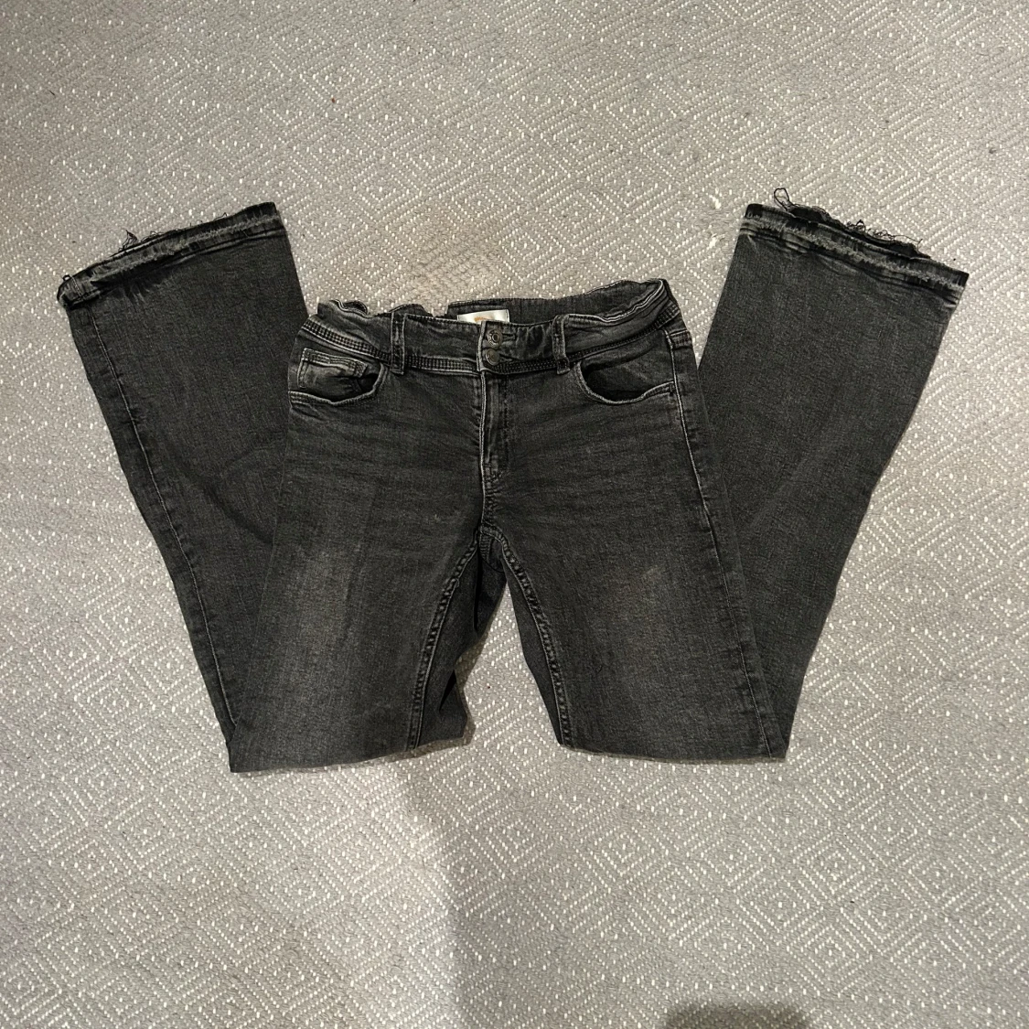 Svarta bootcut jeans med råa kanter