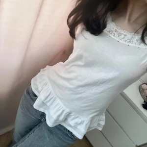 Vit spetstopp - Vit topp med spets och volanger, bra skick, strl XS.