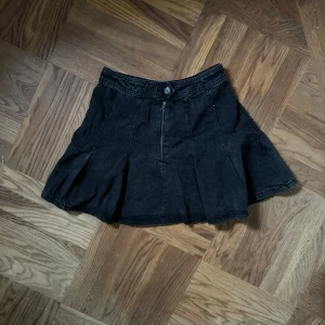 Svart jeanskjol med utställd passform - Säljer en svart jeanskjol med utställd siluett och synliga sömmar. Kjolen har knapp och dragkedja framtill och är i storlek S. Jag är ca 160 för referens 🪼