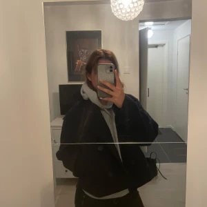 Marinblå  kort kappa med knappar - Säljer en marinblå , kort kappa med stora knappar framtill. Jackan har en oversized passform och långa ärmar. Perfekt för dig som gillar en stilren och enkel look.