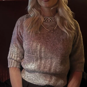 Grå stickad tröja med pärldetaljer från Zara - Mysig grå stickad tröja från Zara med glittrande pärldetaljer runt halsen. Tröjan har trekvartsärm och två fickor framtill. Perfekt för att lyfta en enkel outfit. Tröjan är endast använd en gång🥂