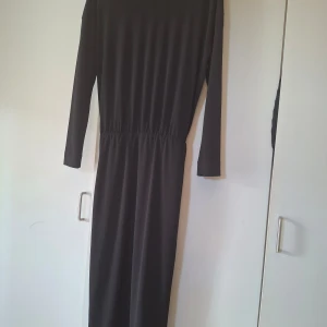 Svart långklänning med v-ringning - Säljer min klänning från Malene Birger. Den har djup v-ringning och kan bäras på båda håll. Den har långa ärmar och är vadlång. Klänningen har resår i midjan för en smickrande passform och är perfekt för dig som gillar en stilren och elegant look. 