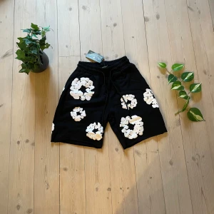 Mörkblå shorts från Denim Tears - Mörkblåa shorts från Denim Tears. Shortsen har resår i midjan och snörning för justerbar passform. Perfekta för en avslappnad stil och tillverkade i mjukt material.