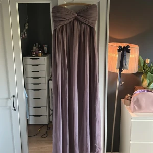 Ljuslila långklänning från NLY Trend - Säljer en romantisk ljuslila långklänning från NLY Trend med axelbandslös design. Klänningen har en flowy passform och är perfekt för bal eller fest. Använd endast 1 gång🌸🌸🌸💖💖