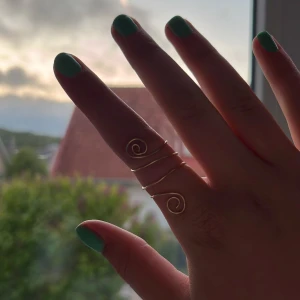  Spiralring i guldtråd - Unik ring i guldtonad metalltråd med spiralformad design. Ringen har flera snirkliga detaljer och är justerbar för att passa olika fingrar. Perfekt för dig som gillar bohemisk och personlig stil. Pris går att diskutera❤️