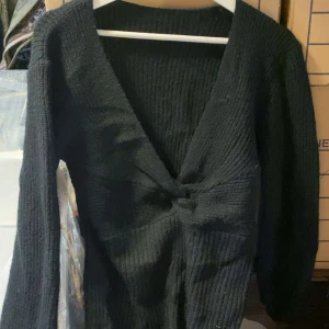Svart ribbad omlottkofta - Säljer en svart ribbad omlottkofta med lång ärm och knutdetalj framtill. Perfekt att slänga över en topp för en snygg lager-på-lager-look. Supermjuk och skön att ha på sig!