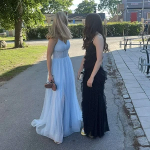 Ljusblå långklänning med slits  - Säljer en drömmig ljusblå balklänning med tunna justerbara axelband och v-ringning. Klänningen har en hög slits framtill och ett flowigt fall. Perfekt för bal eller student.